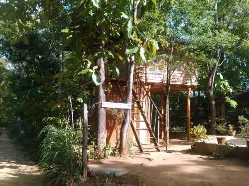 a small tree house with a sign in front of it at Angry Birds Tree house in Habarana