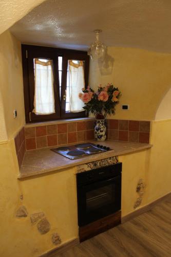 a kitchen with a stove and a vase of flowers at La Giada in Tivoli
