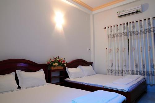 a bedroom with two beds and a window at Diep Anh Guest House in Ho Chi Minh City