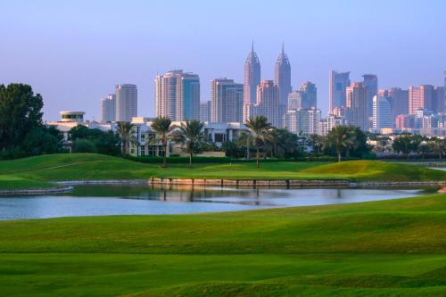 a golf course with a view of the city at Address Montgomerie in Dubai