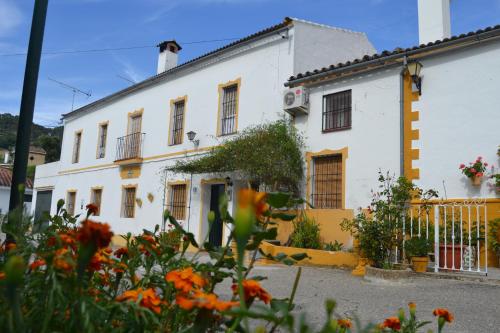 ein weißes Haus mit Blumen davor in der Unterkunft El Antiguo Molino in El Bosque