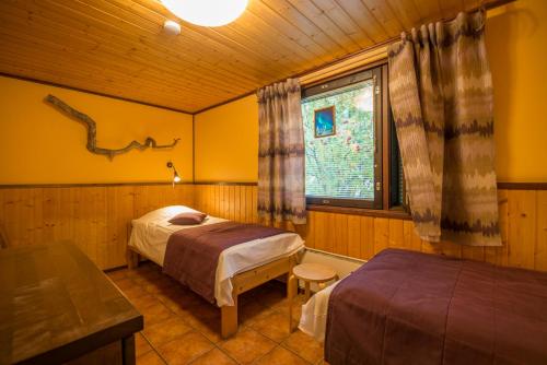 a bedroom with two beds and a window at Ylläksen Yöpuu in Äkäslompolo