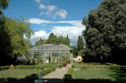 a glass greenhouse in the middle of a garden at Chateau de Raissac in Béziers
