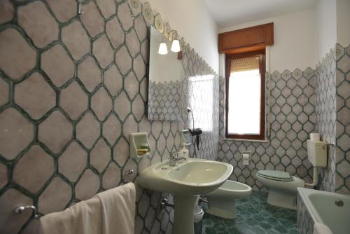 a bathroom with a sink and a toilet and a mirror at Liberty Guest House in Alghero