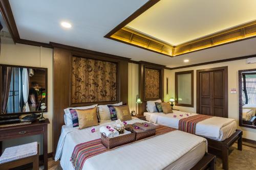 a hotel room with two beds in a room at Wannamas Chiangmai Boutique House in Chiang Mai