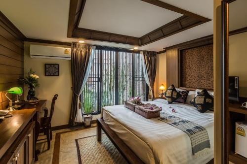 a bedroom with a large bed and a window at Wannamas Chiangmai Boutique House in Chiang Mai