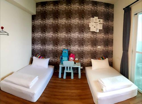 a room with two beds and a table with a laptop at 22 B&B in Donggang