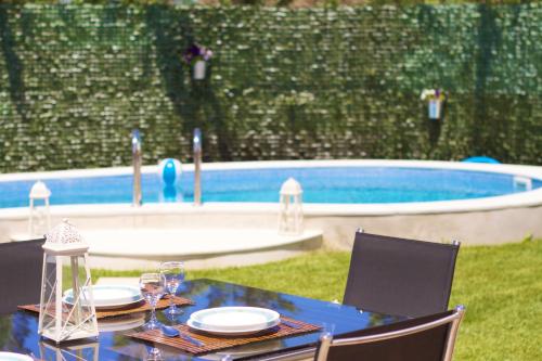 a blue table with plates and wine glasses next to a pool at Blue Paradise in Margarítai