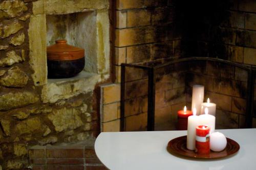 two candles sitting on a table with a stone wall at Blue Paradise in Margarítai