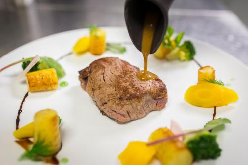 a plate of food with a piece of meat and sauce at Excelsior Chamonix Hôtel & Spa in Chamonix-Mont-Blanc