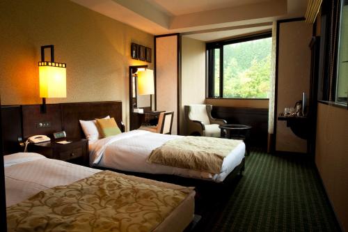 Komagane Kogen Resort Linx في كوماغان: غرفة فندقية بسريرين ونافذة