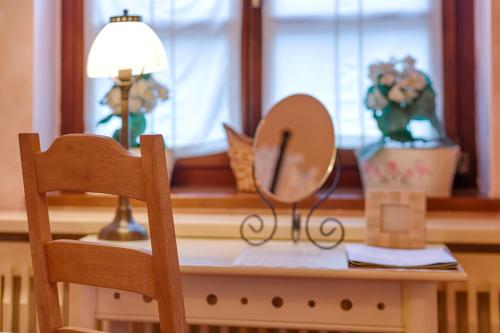 a mirror sitting on a table next to a window at Villa Rosa in Dunajská Streda