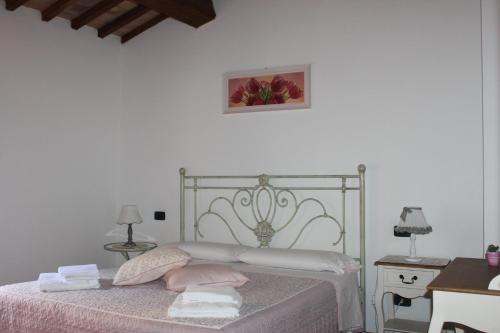 a bedroom with a bed with pink sheets and towels at Alla Porta di Sopra in Castiglione dʼOrcia