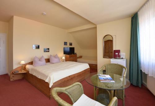 a hotel room with a bed and a table at Pension Villa Gisela in Weimar