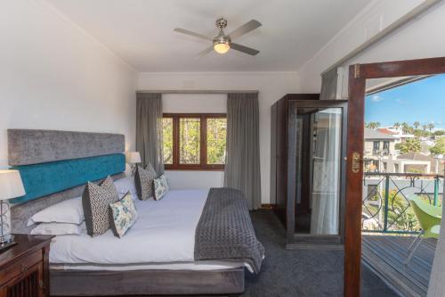 a bedroom with a bed and a balcony at Maartens Guesthouse in Cape Town