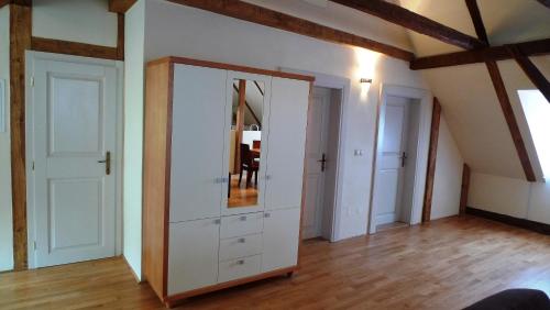 una stanza con un mobile bianco con uno specchio di Apartmány Scharffenberg a Banská Štiavnica