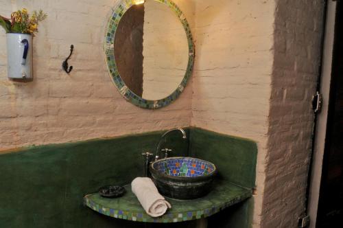 a bathroom with a sink and a mirror at LAS JARILLAS Hostería & Bodega in San Javier