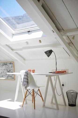 a white table and a chair in a room at InAweStays Holiday Homes in Cape Town