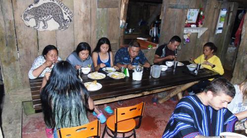 a group of people sitting at a table eating food at Posada Fin del Mundo in Mocoa