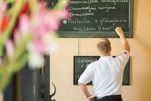 a man standing in front of a chalkboard at Villa Rosa in Dunajská Streda