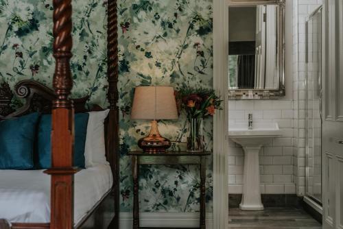 a bedroom with a bed and a sink and a lamp at Healing Manor Hotel in Grimsby