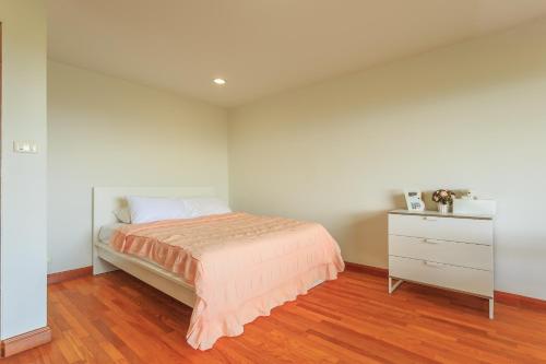 a bedroom with a bed and a dresser at Phuripimarn Penthouse in Pak Chong