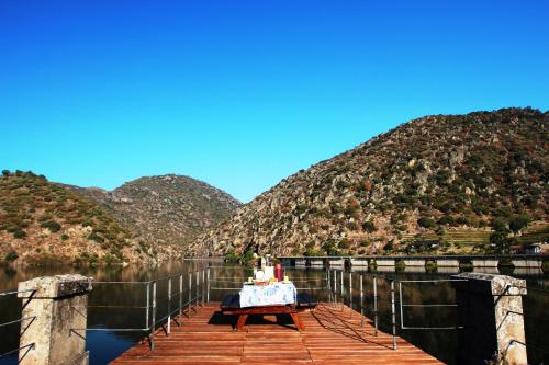 una mesa en un muelle en medio de un lago en Douro Yacht Charter & Bungalows, en São João da Pesqueira