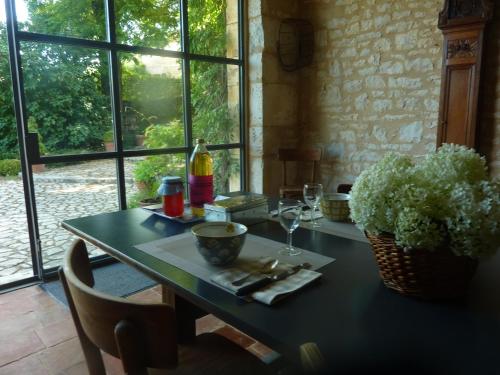 une table avec des verres à vin et une plante dessus dans l'établissement LA CLE d'ESCAMPS, à Escamps