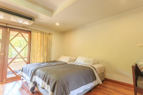 a bedroom with a bed and a window at Phuripimarn Penthouse in Pak Chong