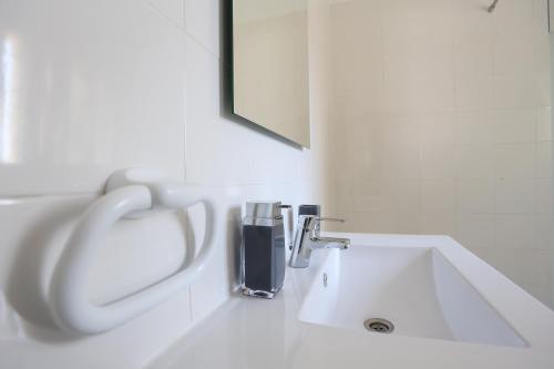 カスカイスにあるSuites Apartmentsの白いバスルーム(シンク、蛇口付)