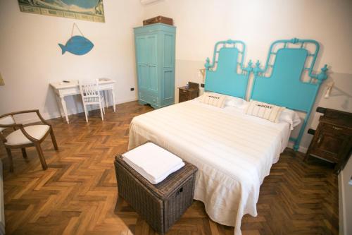 Schlafzimmer mit einem blauen Bett und einem Tisch in der Unterkunft b&b ocagiuliva in Riparbella
