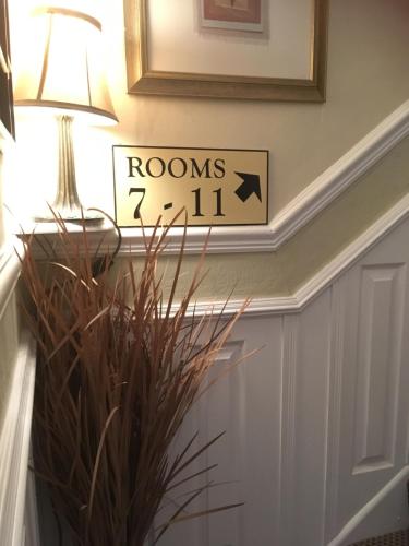 a sign that says rooms fall on a wall next to a plant at Abbey Court Guest House in Carlisle