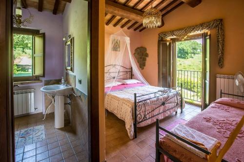 1 dormitorio con 1 cama y baño con lavamanos en Il Casale di Aurora Country House, en Colmurano