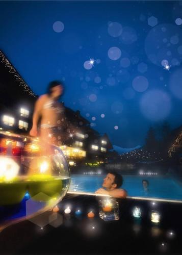 a group of people in a swimming pool at night at Hotel Eterlou in Méribel