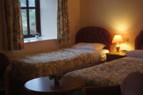 a hotel room with two beds and a window at Mullacott Farm in Ilfracombe