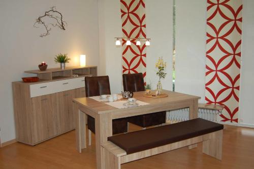 ein Esszimmer mit einem Tisch und einer Küche in der Unterkunft Ferienwohnung_Beethovenstrasse in Westerstede