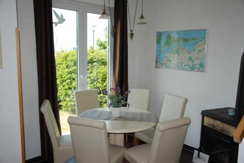 a dining room with a table and chairs and a window at Ferienhaus am Saaler Bodden in Neuendorf