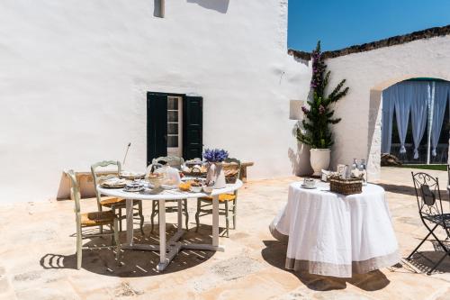 a table and chairs in a courtyard with a table and chairs at Masseria Luco in Martina Franca