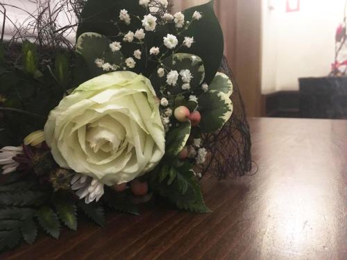 a bouquet of white flowers and plants on a table at Пансион Роди in Silistra