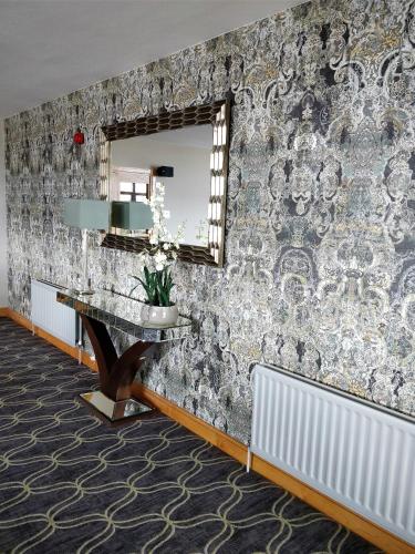 a bathroom with a mirror and a table and radiator at Cromore Halt in Portstewart
