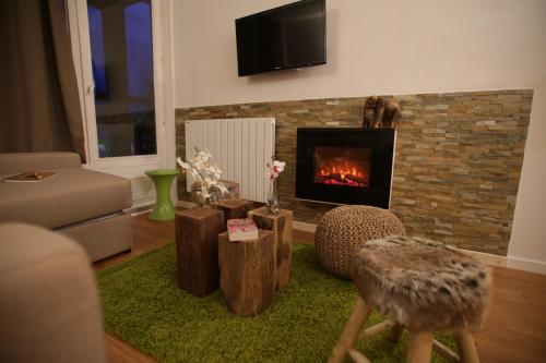 ein Wohnzimmer mit Kamin und Couch in der Unterkunft ARC 1800 Appartement 4 pièces Lauzières skis aux pieds in Arc 1800