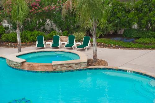 a swimming pool with lounge chairs and a swimming pool at Casa Del Mar Beachfront Suites in Galveston