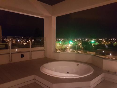 a bathroom with a large bath tub in front of a window at Apartamento Reyes Catolicos in Salta