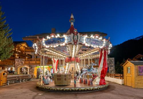 a merry go round at an amusement park at night at Hotel Eterlou in Méribel