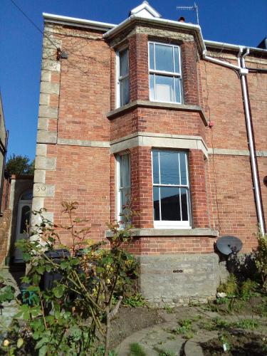 a brick building with two windows on the side of it at Town House Bridport Dorset in Bridport