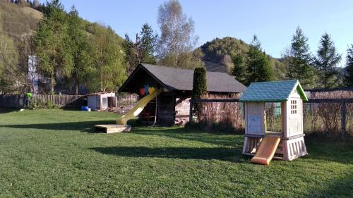 a playground with a slide and a play house at Casa Moeciu Family in Moieciu de Jos