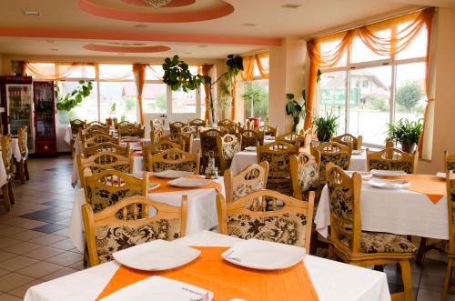 シェリンバルにあるMotel Draculaの白いテーブルと椅子、窓のあるレストラン