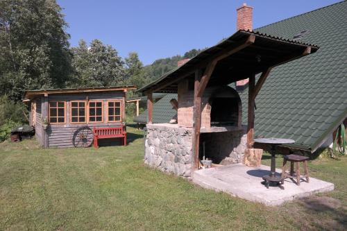 a building with a grill and a house at Casa Moeciu Family in Moieciu de Jos