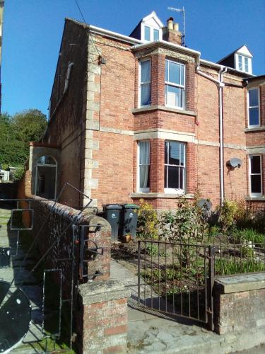 an old brick house with a gate in front of it at Town House Bridport Dorset in Bridport