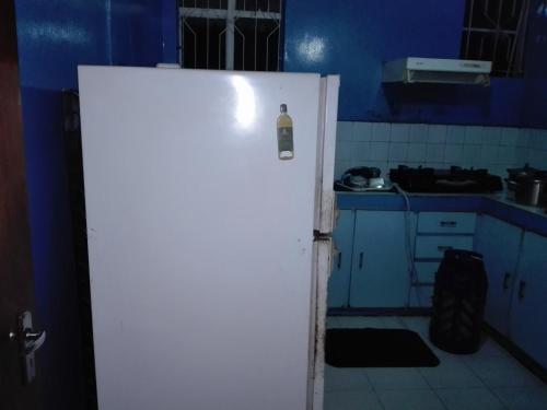 an open door to a kitchen with blue walls at Maison Au pied du Volcan in Curepipe